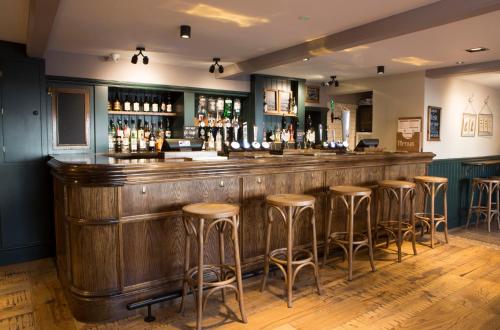 a bar in a pub with stools at Crown and Cushion Appleby in Appleby