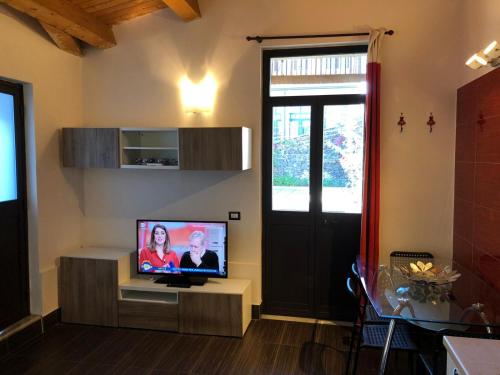 a living room with a flat screen tv on a stand at Green Orange Catania Ognina in Catania