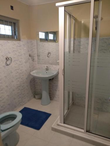 a bathroom with a toilet and a sink and a shower at Windsor Forest bungalow in Bandarawela