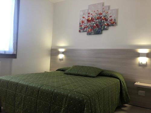 a bedroom with a bed with a green bedspread at Appartamenti Fiordaliso in Sirmione