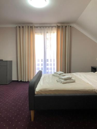 a bedroom with a bed with towels on it at Casa Codrin in Bran