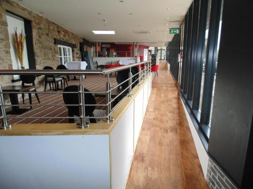 a long corridor in a restaurant with a table and chairs at Best Western Plus Lancashire Manor Hotel in Skelmersdale