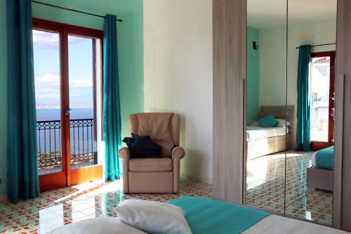 una camera con letto e sedia e un balcone di Villa Marylise a Sorrento