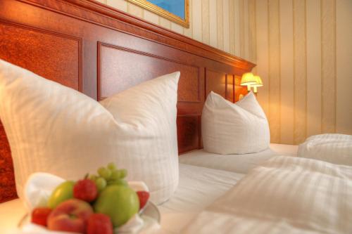 a hotel room with two beds with fruit on a plate at SEETELHOTEL Ahlbecker Hof das elegante Traditionshotel & ruhiger Rückzugsort an der Ostsee in Ahlbeck