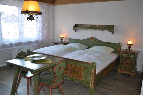 a bedroom with a green bed with a table and a lamp at Landgasthaus Krone in St. Johann in Sankt Johann