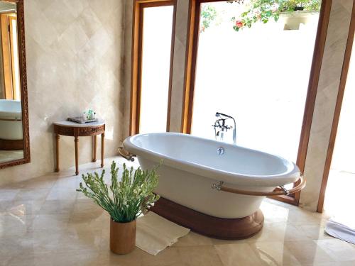 y baño con bañera y ventana grande. en Luxury Villa Perla en Candidasa