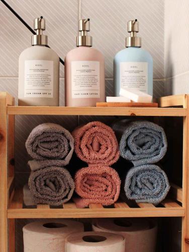 a wooden shelf with towels and bottles of soap at Koel Country House in Áno Almirí