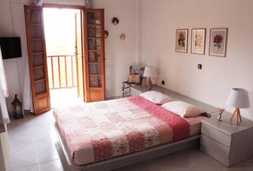 a bedroom with a bed with a red and white blanket at Koel Country House in Áno Almirí