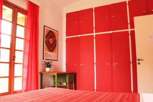 a red bedroom with a bed and red cabinets at Koel Country House in Áno Almirí