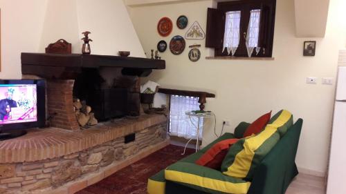 een woonkamer met een open haard en een televisie bij Vicolo Cerese in Ceri