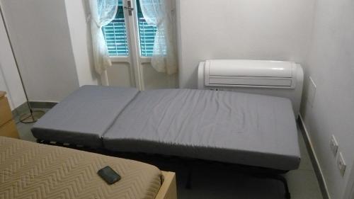 a small room with two beds and an air conditioner at La casa di Balto, un nido per 2 in Castelnuovo Magra