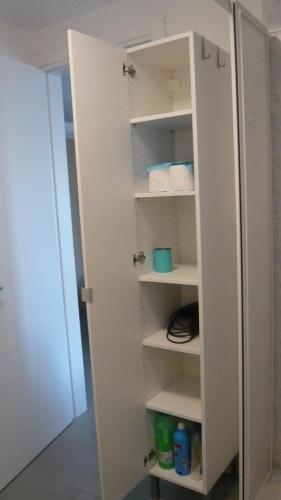 a white cabinet with shelves in a room at La casa di Balto, un nido per 2 in Castelnuovo Magra