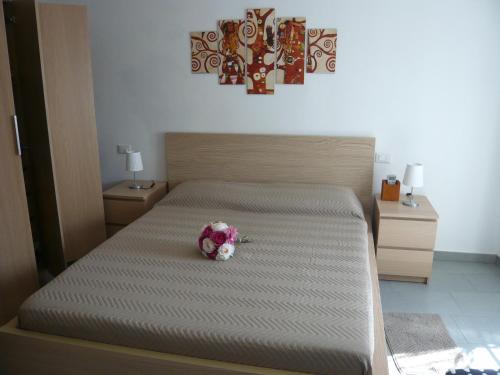 a bed with a bouquet of flowers on it at La casa di Balto, un nido per 2 in Castelnuovo Magra