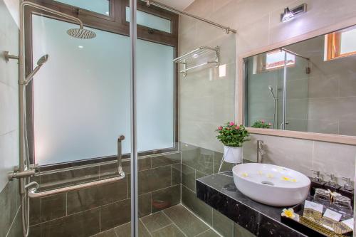 a bathroom with a sink and a glass shower at Square Villa Hoi An in Hoi An
