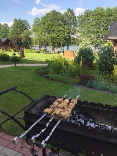 a grill with meat on skewers cooking on it at Vila Viesai in Trakai