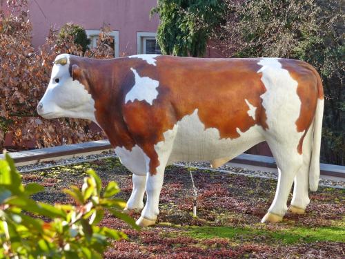 a statue of a brown and white cow standing in the grass at Hotel-Restaurant zum Ochsen in Schallstadt