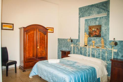 ein Schlafzimmer mit einem Bett und einem Wandgemälde in der Unterkunft B&B Pietrafitta in Carovigno