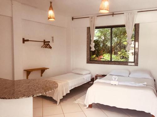 杰里科科拉Casa Mar Suites的有两张床和一扇窗户的房间