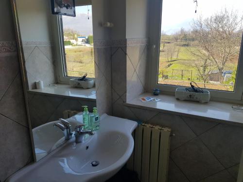 baño con lavabo, espejo y ventana en B&B il Feudo, en Fontechiari