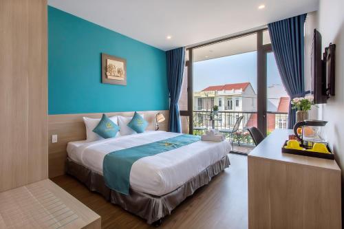 a bedroom with a large bed with a blue wall at Square Villa Hoi An in Hoi An