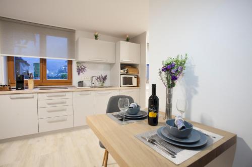 een keuken met een tafel, glazen en een fles wijn bij Studio Jan in Zgornje Gorje