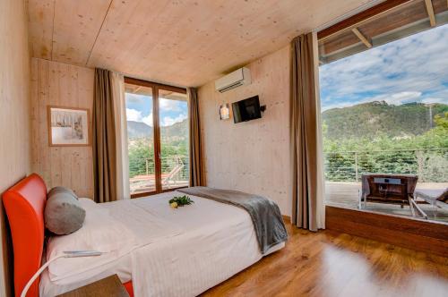 a bedroom with a bed and a large window at GeoResort in Tremosine Sul Garda