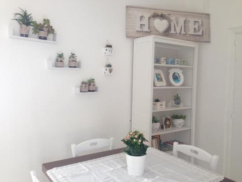 a dining room with a table and a shelf with plants at Lulù Marin Casa Vacanze Praia a Mare in Praia a Mare