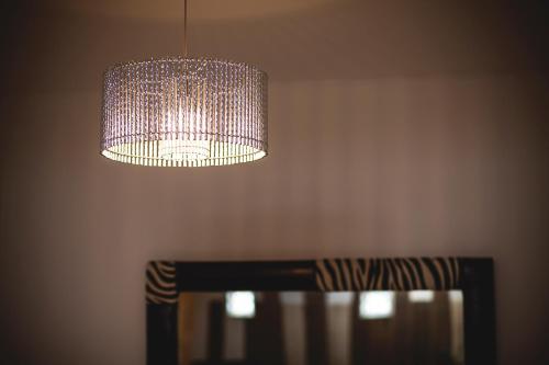 a chandelier hanging over a wooden chair with a table at Junior Suites con Jacuzzi in Babilafuente