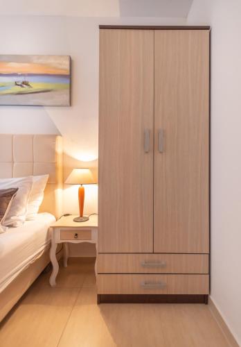 a bedroom with a large wooden cabinet next to a bed at Apartment San Marco in Risan