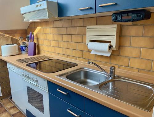a kitchen counter with a sink and a stove at Annes Ferienwohnung Freiburg in Vörstetten