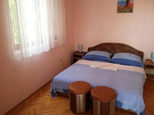 a bedroom with a large bed with two stools at Apartments & Hostel Zdrava Hrana in Mostar