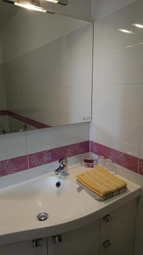 a bathroom sink with a yellow towel on it at La Ferme Fleurie in La Roque-Gageac