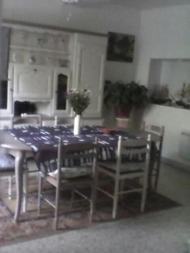 une table à manger et des chaises avec un chiffon bleu dans l'établissement La maison des vendangeurs, à Trausse