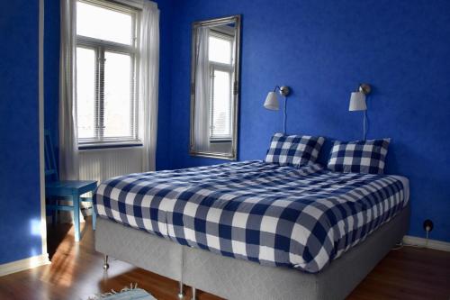 a blue bedroom with a bed with a blue wall at Mooi! Gula Huset in Lidhult