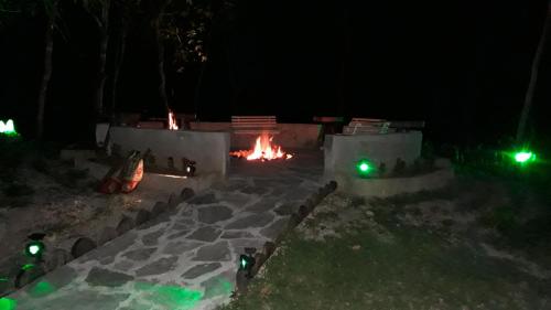 a fire pit at night with green lights at Pousada Cachoeira Poço Encantado in Alto Paraíso de Goiás