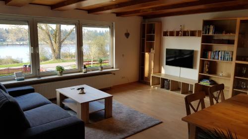 a living room with a couch and a table at Ferienwohnung mit wunderschönem Blick auf den Nord-Ostsee-Kanal in Breiholz
