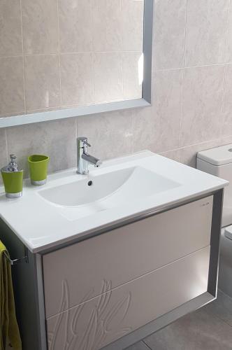a bathroom with a white sink and a mirror at Casa Cordieira in Combarro