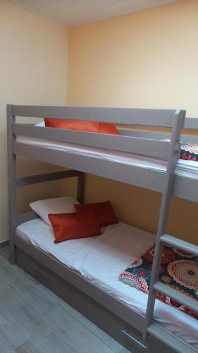 - 2 lits superposés avec des oreillers rouges et une échelle dans l'établissement Maison en bord de mer, à La Faute-sur-Mer