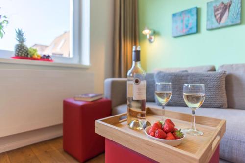 a bottle of wine and two glasses on a table at neyland apartments Norderney in Norderney