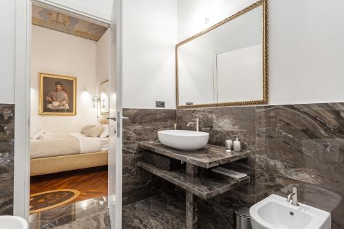 ローマにあるPalazzo Del Duca Piazza Navona Guest Houseのバスルーム(洗面台、鏡付)