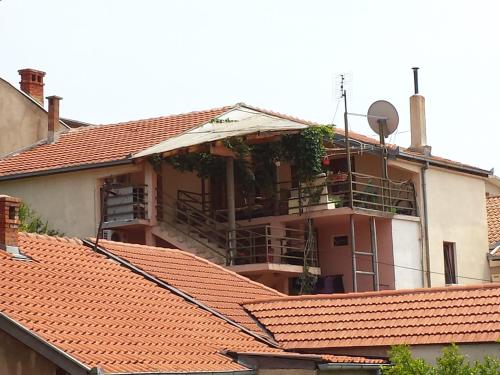 a building with red tile roofs with a satellite at Apartments & Hostel Zdrava Hrana in Mostar
