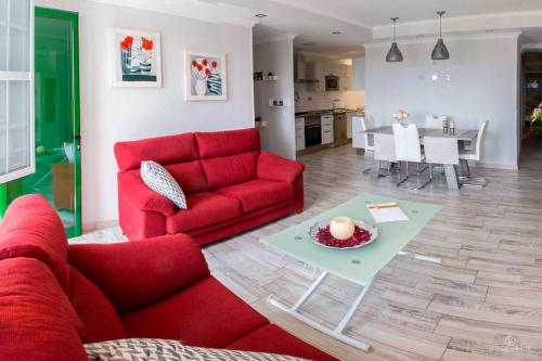 salon z czerwoną kanapą i stołem w obiekcie Sarelen w mieście Santa Cruz de la Palma