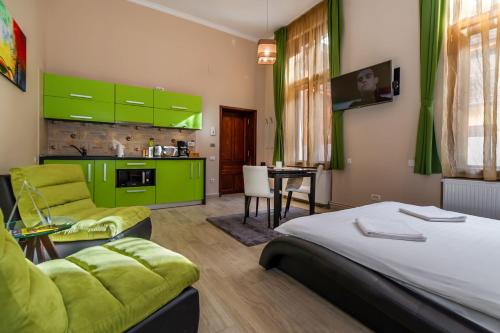 a bedroom with a bed and a kitchen with green cabinets at Select City Center Apartments in Braşov