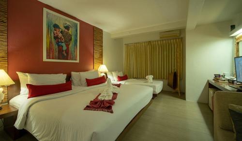 a hotel room with two beds and a television at Villa Cha-Cha Banglumphu in Bangkok