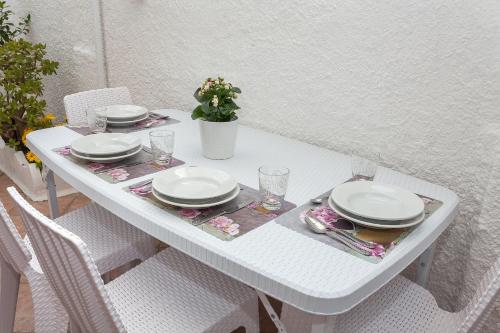 a white table with plates and dishes on it at Lulù Marin Casa Vacanze Praia a Mare in Praia a Mare