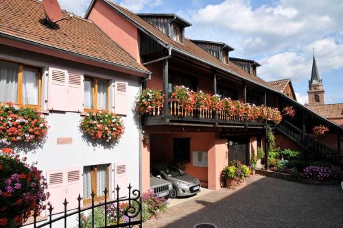 un bâtiment avec des boîtes de fleurs sur les balcons dans l'établissement Gite Weyer n°3, à Bergheim