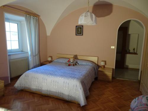 um quarto com uma cama e uma grande janela em B&B San Valentino em Giovo