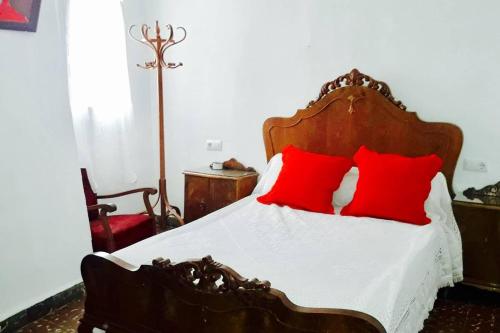 a bedroom with a wooden bed with red pillows at Casa De Enguídanos in Enguídanos