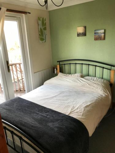 a bedroom with a white bed with a window at Glangwna Holiday Park in Caernarfon