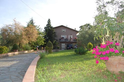 een tuin met roze bloemen en een huis bij Agriturismo Campo Contile in Chianciano Terme